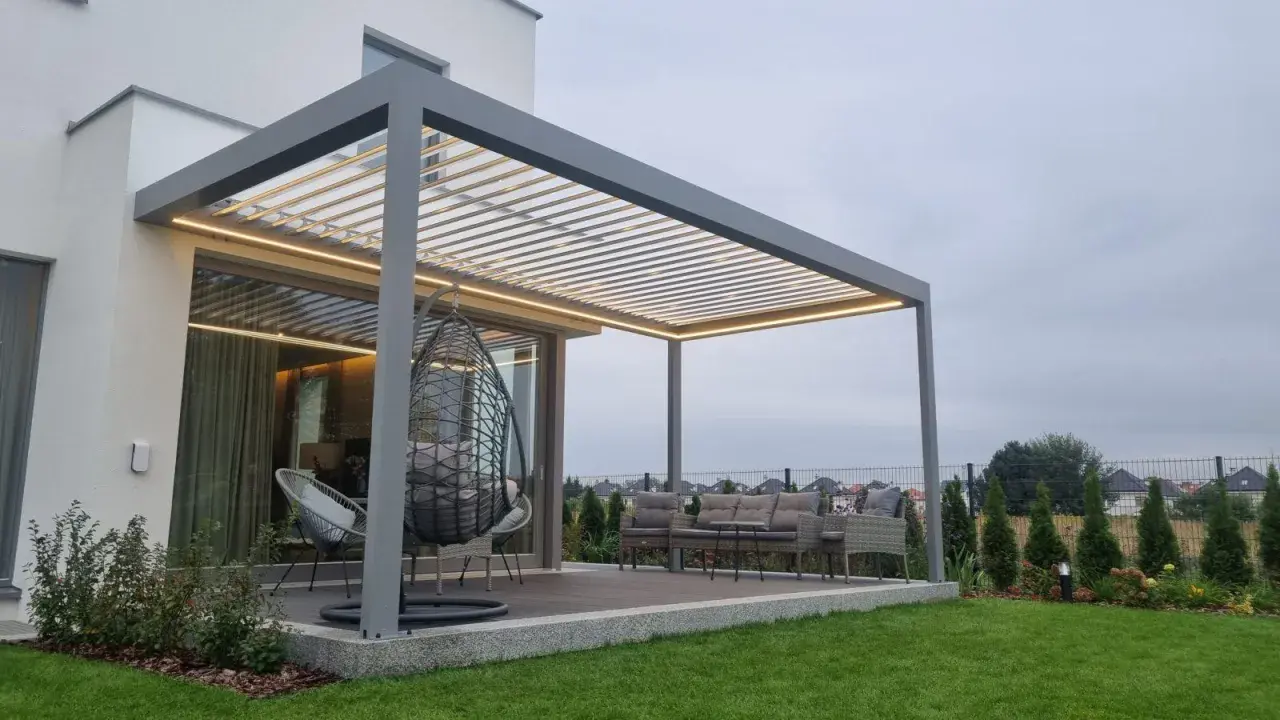 Nowoczesna pergola z oświetleniem LED, huśtawką i meblami ogrodowymi.