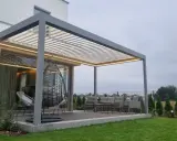 Nowoczesna pergola z oświetleniem LED, huśtawką i meblami ogrodowymi.