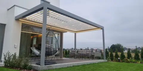 Nowoczesna pergola z oświetleniem LED, huśtawką i meblami ogrodowymi.