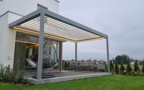 Nowoczesna pergola z oświetleniem LED, huśtawką i meblami ogrodowymi.