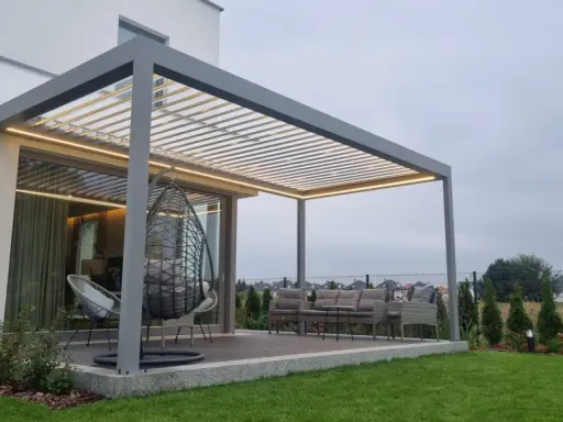 Nowoczesna pergola z oświetleniem LED, huśtawką i meblami ogrodowymi.